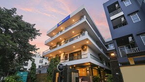 A multi-story hotel with a sign reading "fab hotels". It features a modern architectural design with balconies and a well-lit entrance. - Fabhotel City Suits (Gurugram)
