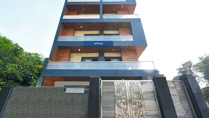 A multi-story building with a sign 'Via' on the facade, featuring balconies and a gated entrance. - Fabhotel Vibe (Noida)