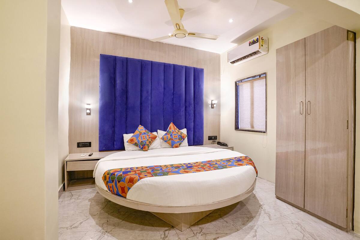 Una habitación de hotel moderna con una cama grande, un escritorio y un armario.