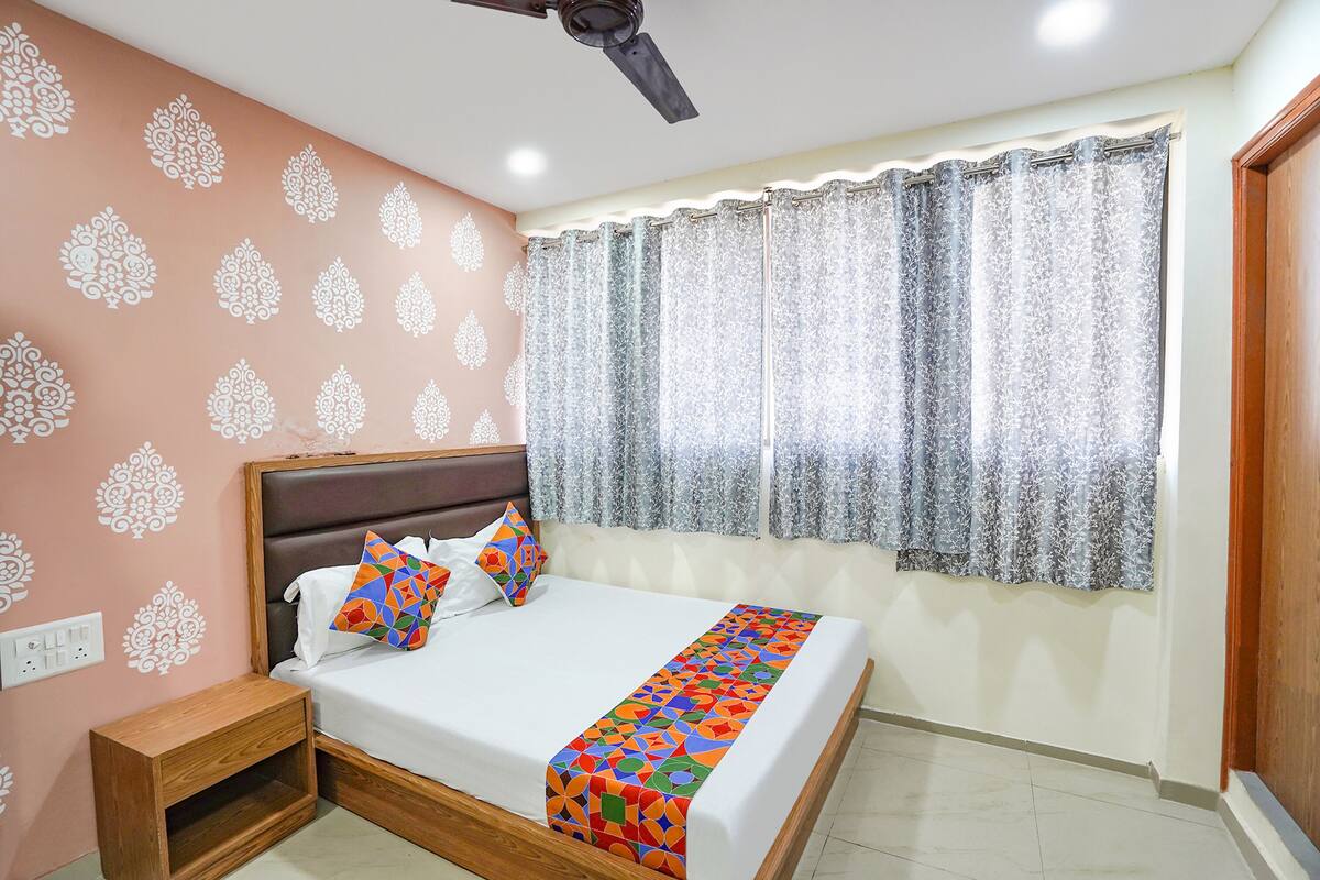 A neatly arranged bedroom with a bed, nightstand, and a ceiling fan.