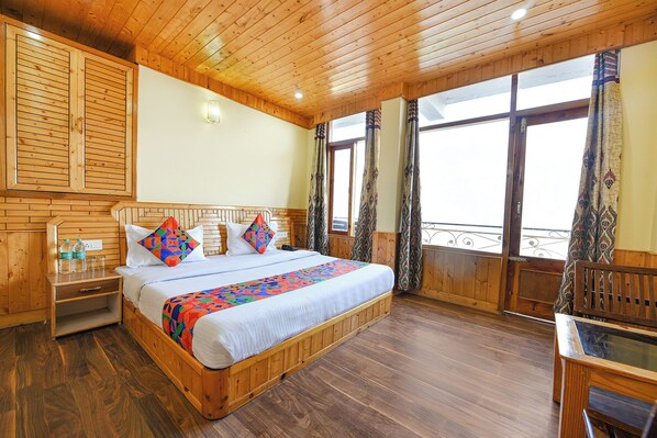 A wooden-paneled bedroom with a bed, bedside tables, and a view through large windows. - Fabhotel Anant Meadows (Manali)