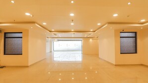 A spacious, well-lit hallway with a tiled floor and recessed ceiling lights. - Fabhotel Rachna Palace And Banquets (Lucknow)