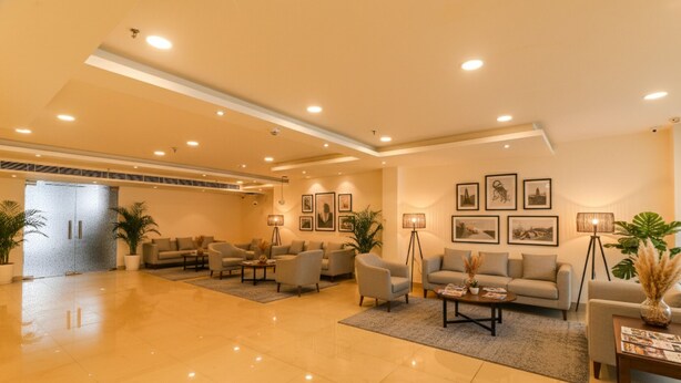 A spacious lobby with a polished floor, multiple seating areas, and framed artwork on the walls. - Fabhotel Rachna Palace And Banquets (Lucknow)