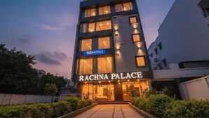 A multi-story hotel named 'Rachna Palace' with a modern facade, illuminated windows, and a visible 'FabHotels' sign. - Fabhotel Rachna Palace And Banquets (Lucknow)