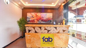 A reception desk with a 'fab hotels' sign, a large floral artwork, and a modern ceiling design. - FabHotel Jingle Tree Resort Nr Arambol Beach (Arambol)