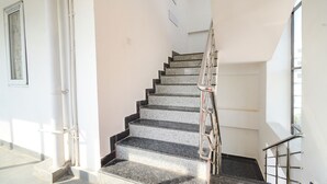 Un escalier avec des rampes et une main courante en métal, menant à l’étage supérieur.