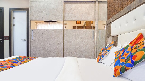 Een hotelkamer met een bed, een garderobe en een spiegel.