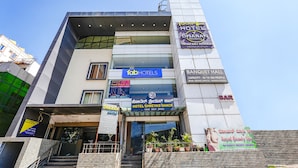 Ein Hotel mit mehreren Schildern, darunter 'Dharan Suites', 'Hotel Shreyas Shack', 'Bar' und 'Dharan'.