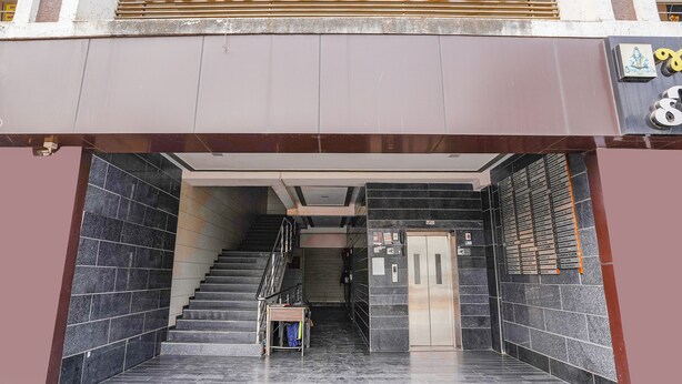 Une entrée moderne avec un escalier menant à un ascenseur.