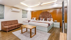 Une chambre moderne avec un grand lit, un canapé, un plancher en bois et un ventilateur de plafond.