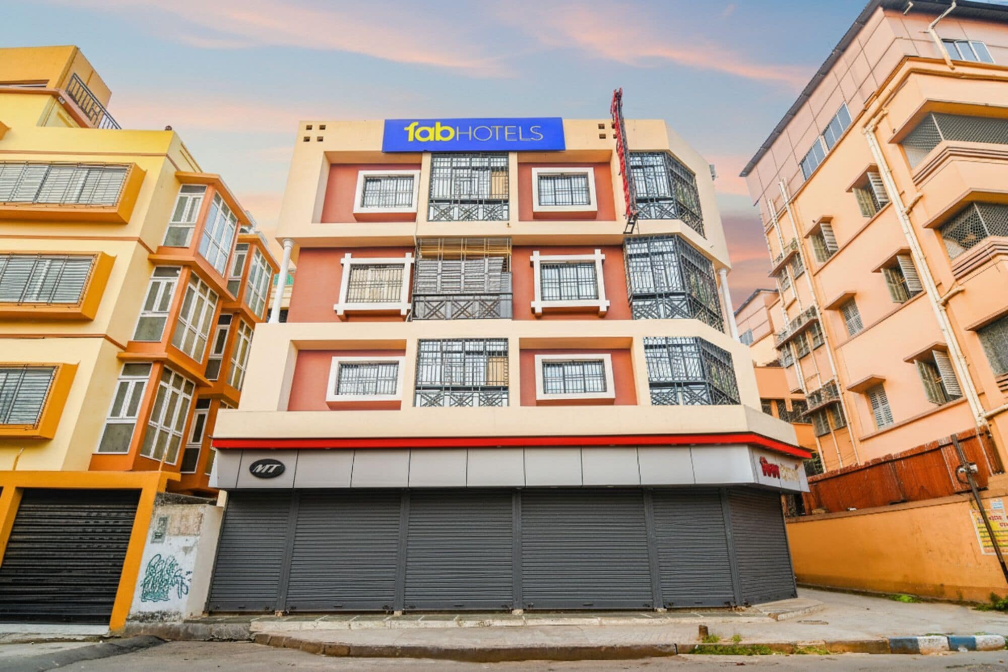 Um edifício com vários andares e uma placa com a inscrição 'fabHOTELS' no topo.