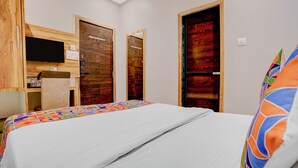 Ein Hotelzimmer mit einem Bett, einem Fernseher und zwei Holztüren.