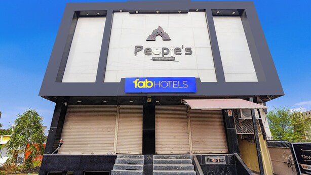 Ένα κτίριο με μια επιγραφή που γράφει «Peoples» και «fab hotels», υποδεικνύοντας ότι πρόκειται για ένα ξενοδοχείο.