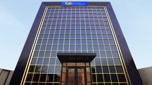 A tall building with a modern glass facade and a sign reading "fabHOTELS" at the top. - Fabhotel Mahalaxmii Grand (Kanpur)