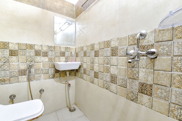 A bathroom with a bathtub, a sink, and a shower. - Fabexpress Sr (Jaipur)