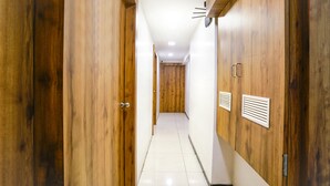A hallway with wooden walls and a tiled floor, leading to a door at the end. - Fabhotel Shiv Leela Grand (Mumbai)