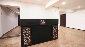 Un comptoir d’accueil d’hôtel avec une pancarte indiquant « fab hotels ».