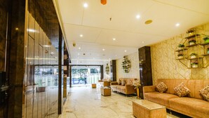 A spacious lobby with a marble floor, a sofa set, a coffee table, and a decorative plant wall. - Fabhotel Prime Seven Lake View (Hyderabad)