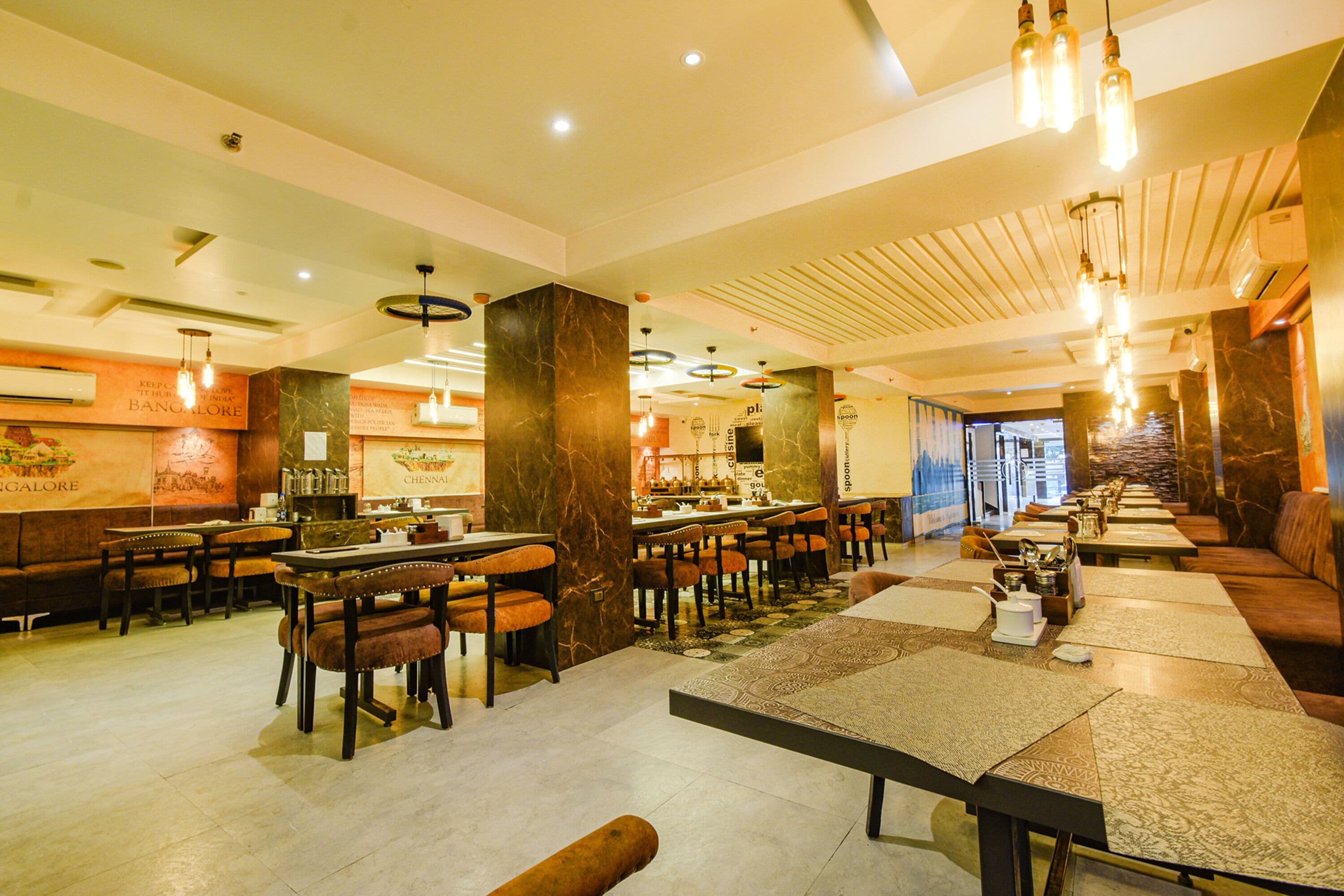 Un restaurante con varias mesas y sillas, una zona de bar y un área de asientos con bancos acolchados.