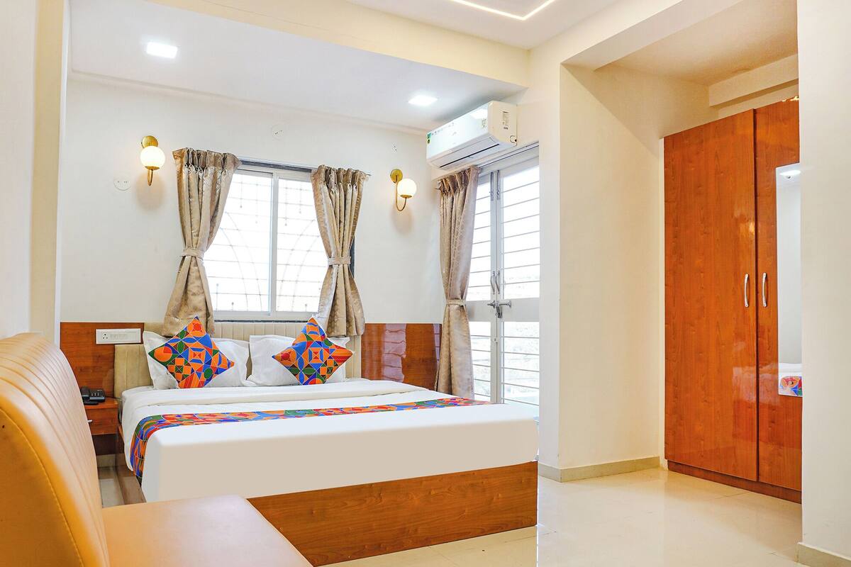 Une chambre d’hôtel équipée d’un lit, de tables de chevet, d’une armoire et d’un appareil de climatisation.