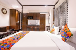 Une chambre d’hôtel comprenant un lit, une table de chevet, une armoire, un téléviseur et une porte de salle de bain.