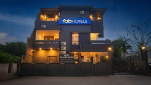 Un edificio moderno con un letrero que dice 'fabHOTELS' y 'HOTEL VILLA THE SUITES'.