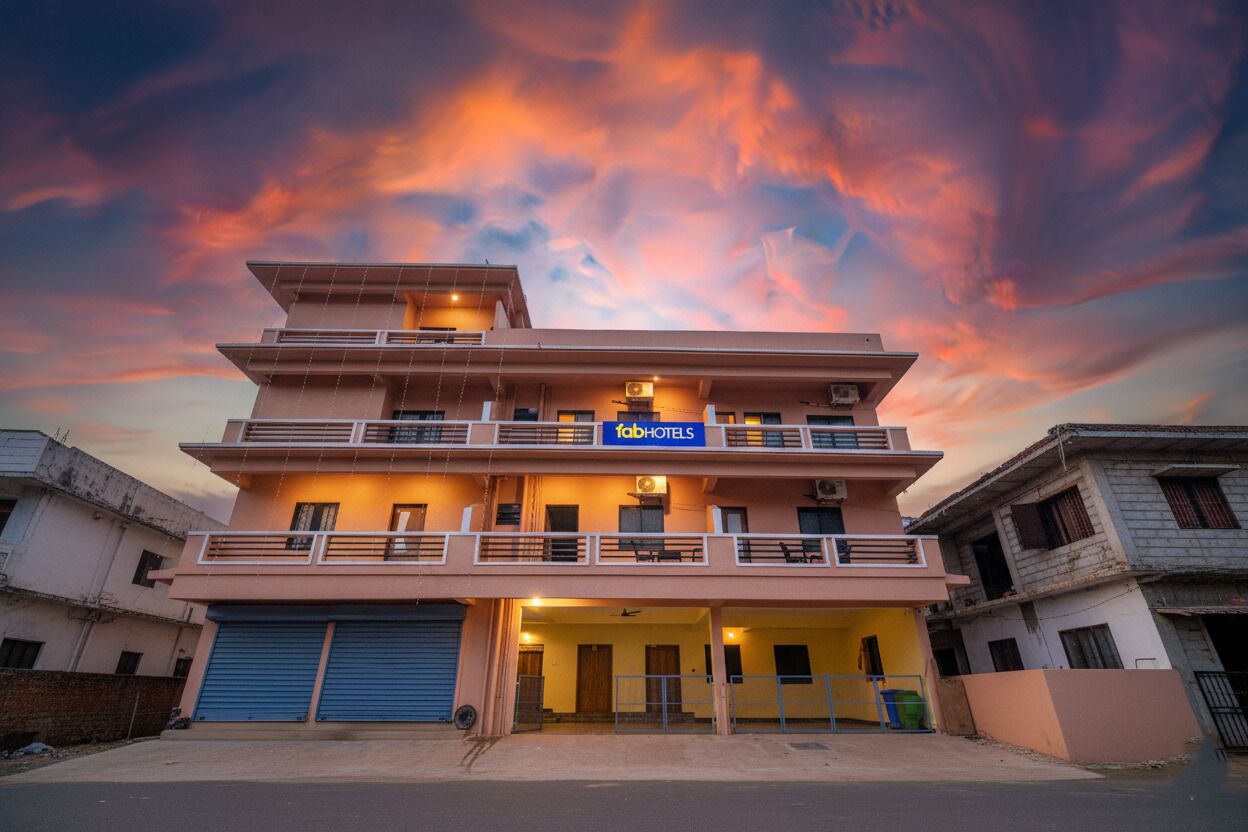 A multi-story hotel with a sign reading "fabHOTELS" and a balcony on the upper floor.