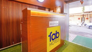 Un comptoir d’accueil dans un hôtel, avec un revêtement en bois et une enseigne indiquant qu’il s’agit de la réception.