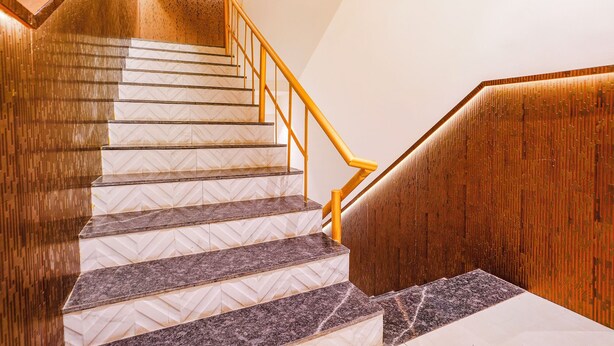 Un escalier avec des rampes en bois et un revêtement de sol à motifs.