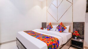Une chambre d’hôtel moderne avec un grand lit, une table de chevet et un élément décoratif mural.