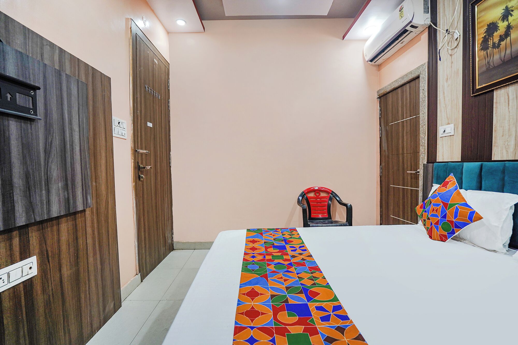 A hotel room with a bed, a chair, and a door.