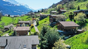 A hillside village with traditional houses, a winding road, and a mountain backdrop. - Lau'tentik by Interhome (Collombey-Muraz)