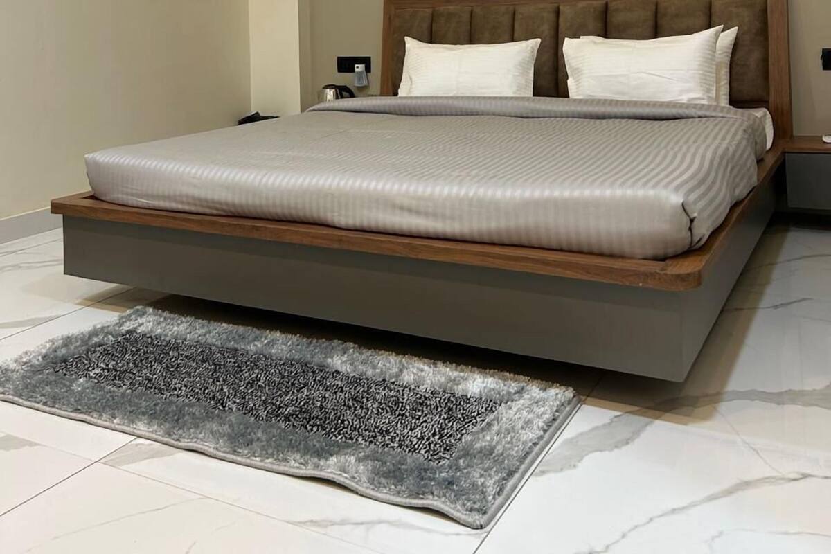 A modern bedroom with a large bed, a ceiling fan, and a wall-mounted artwork.