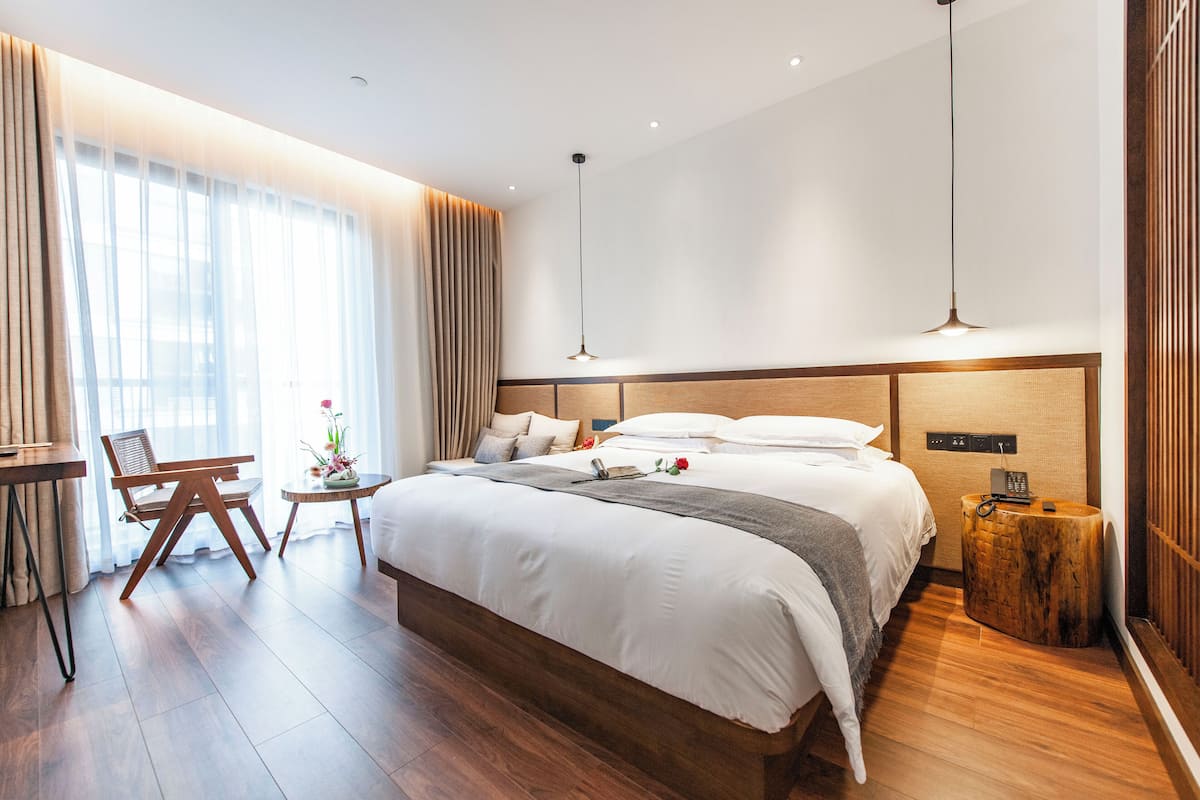 Une chambre d’hôtel moderne, dotée d’un grand lit, d’un bureau et d’une chaise.
