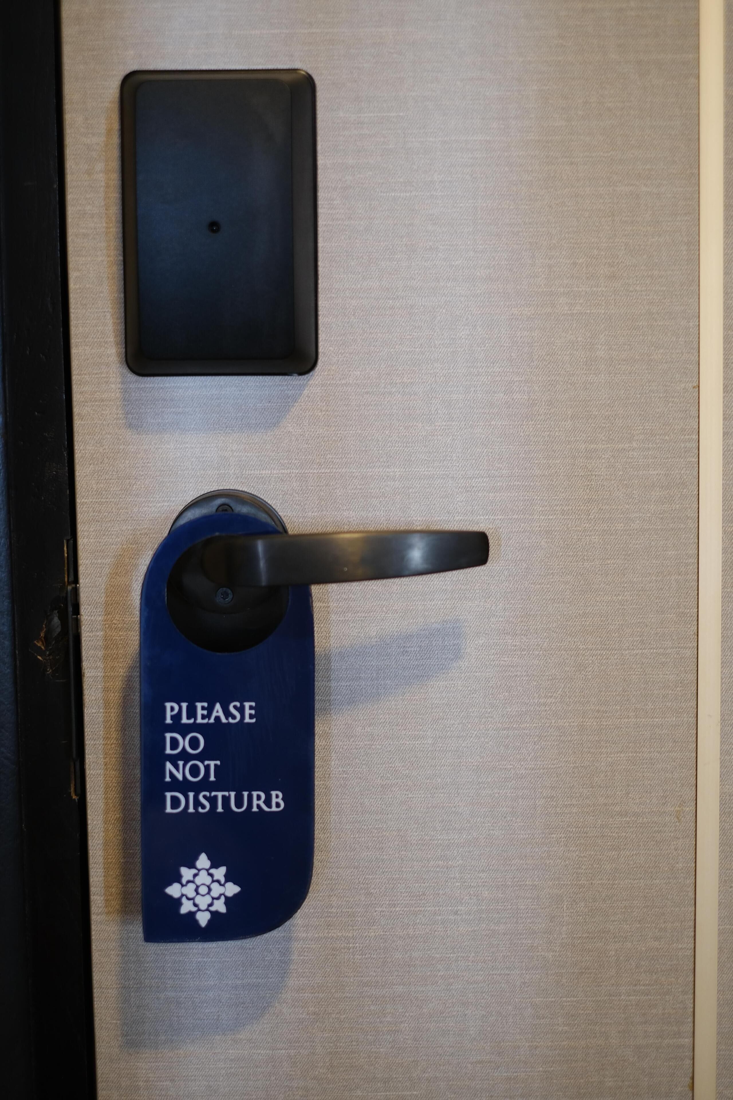 A door with a 'Please Do Not Disturb' sign and a keycard reader.