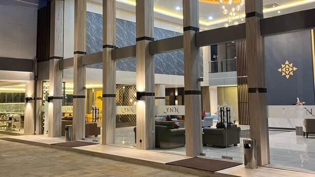 A modern hotel lobby with a spacious layout, large windows, and a central chandelier. - LYNN Hotel Tuban (Tuban)