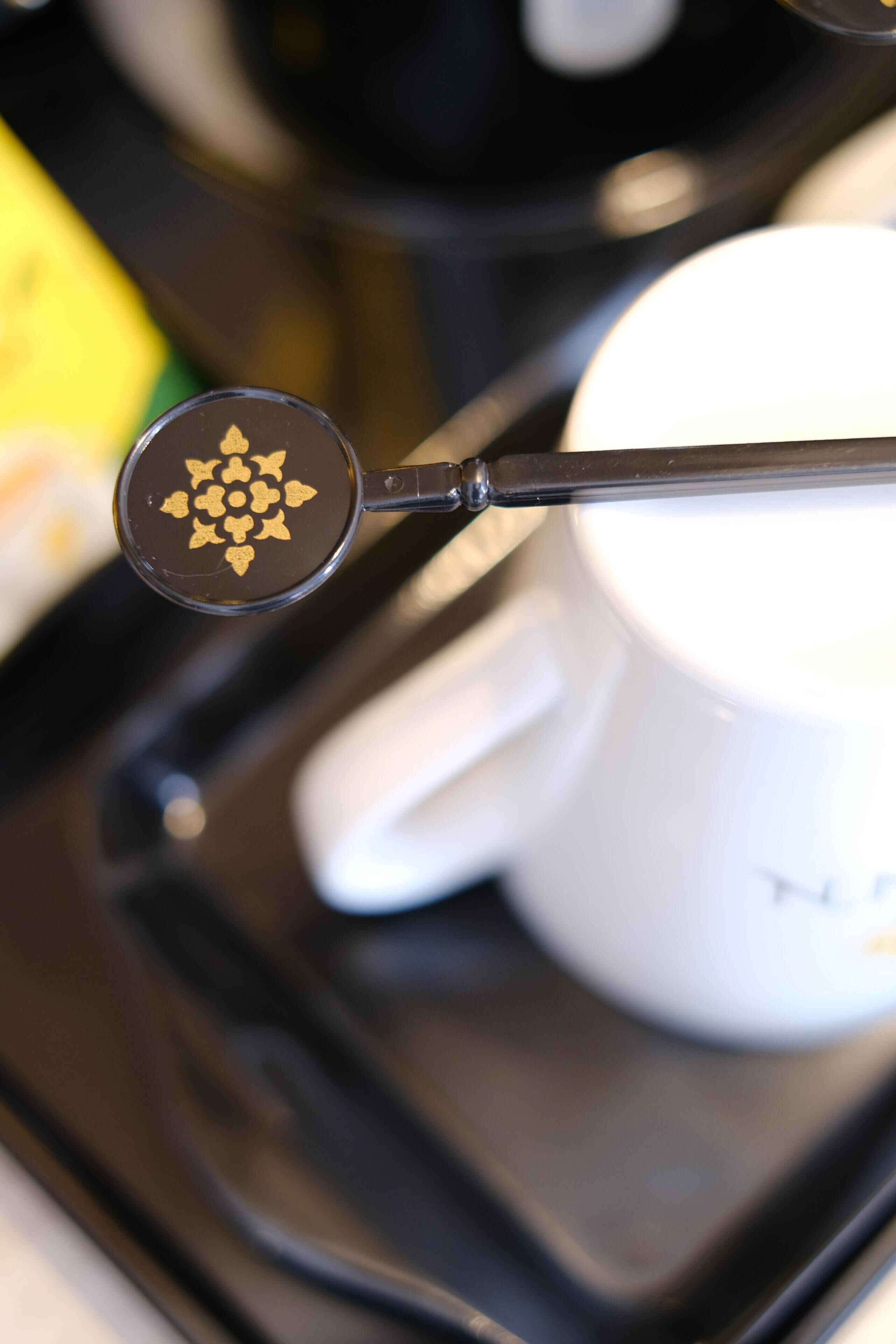 Una cafetera con una cucharada de café sobre una bandeja.