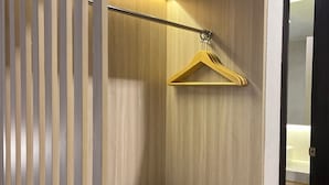 A modern bathroom with a wooden vanity, a towel rack, and a black radio. - LYNN Hotel Tuban (Tuban)