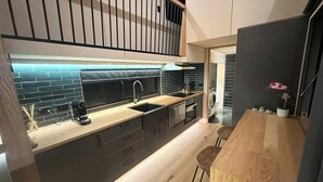 A modern kitchen with a black backsplash, wooden countertops, and a built-in oven.