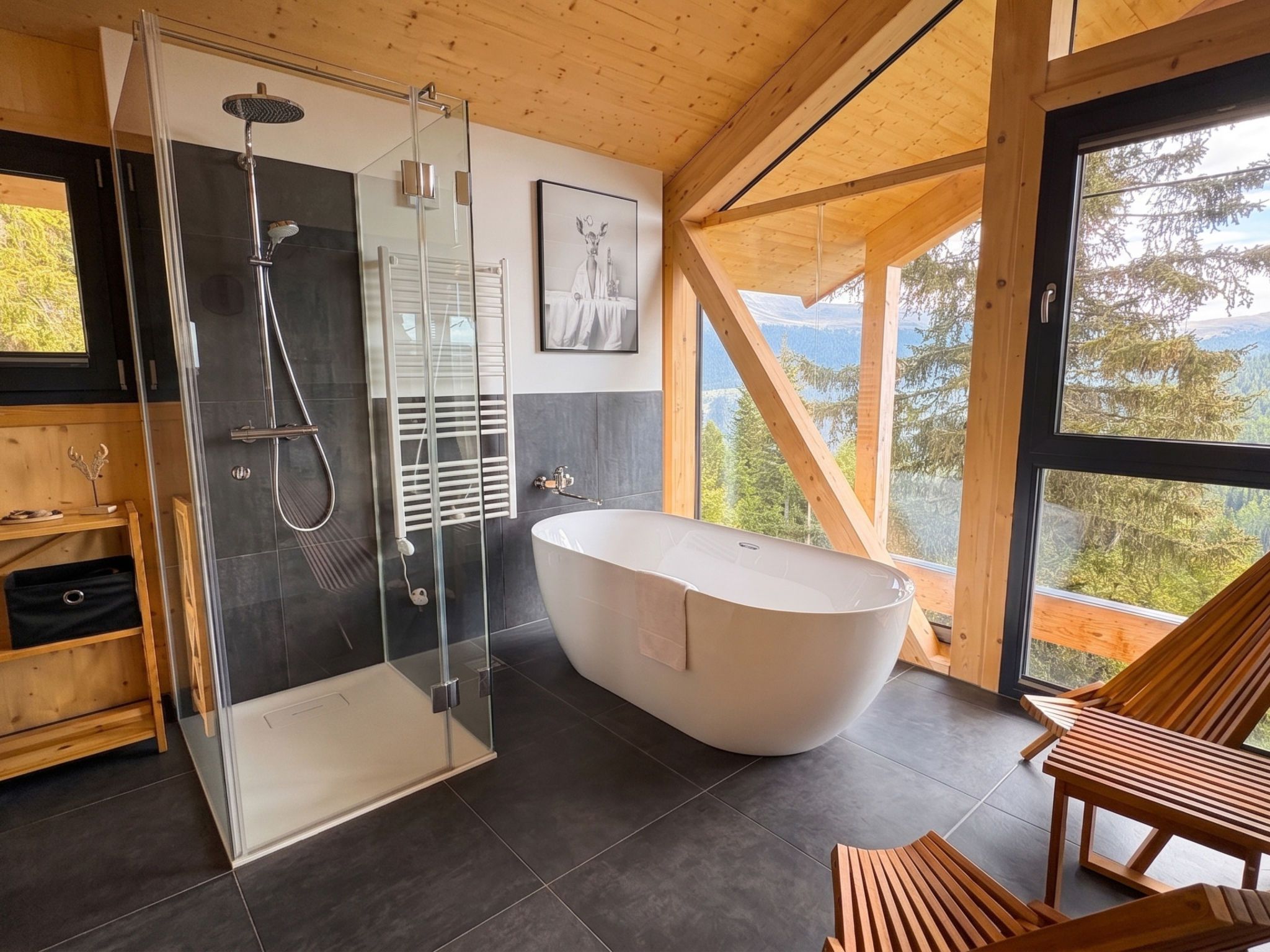 Ein modernes Badezimmer mit freistehender Badewanne, Duschkabine aus Glas und Blick ins Freie.