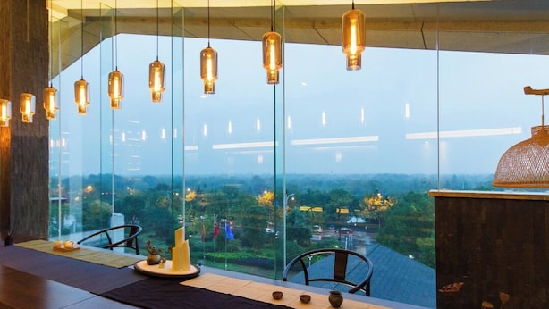A modern interior with a long table, hanging pendant lights, and a large window offering a view of a cityscape. - SSAW Boutique Hotel Hangzhou Xixi NanLu - Close to Xixi Wetland Area (Hangzhou)