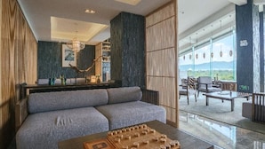 A modern living area with a sofa, coffee table, and a view of the outdoors. - SSAW Boutique Hotel Hangzhou Xixi NanLu - Close to Xixi Wetland Area (Hangzhou)