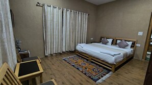 A bedroom with a bed, a desk, and a chair. - LUNGDHO RESIDENCY (Leh)