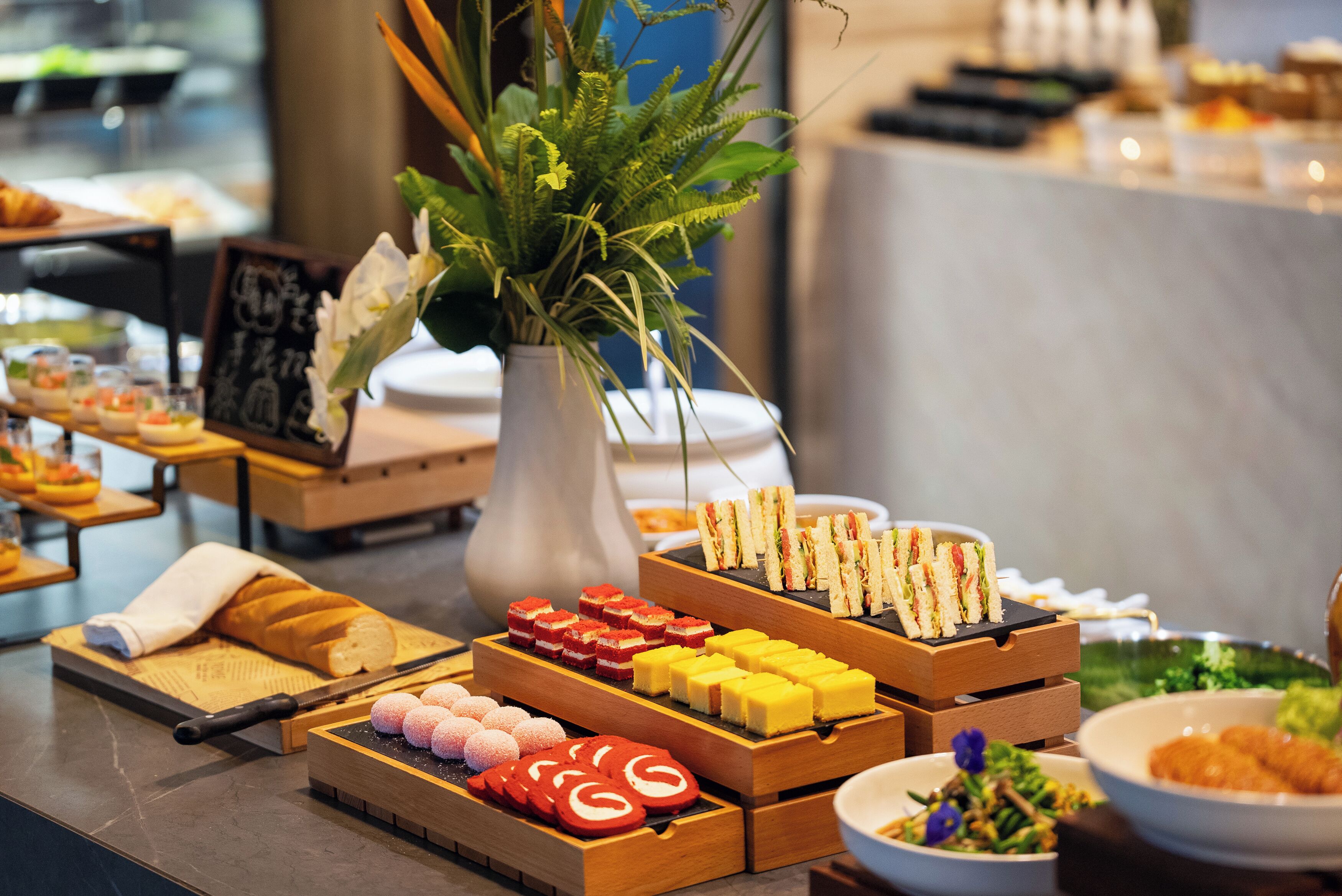 A buffet with various food items, including sandwiches, pastries, and desserts.