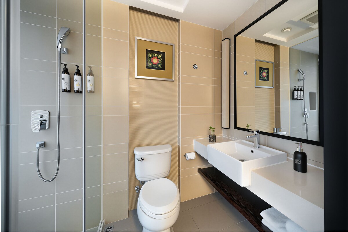 A modern bathroom with a shower, toilet, and sink.