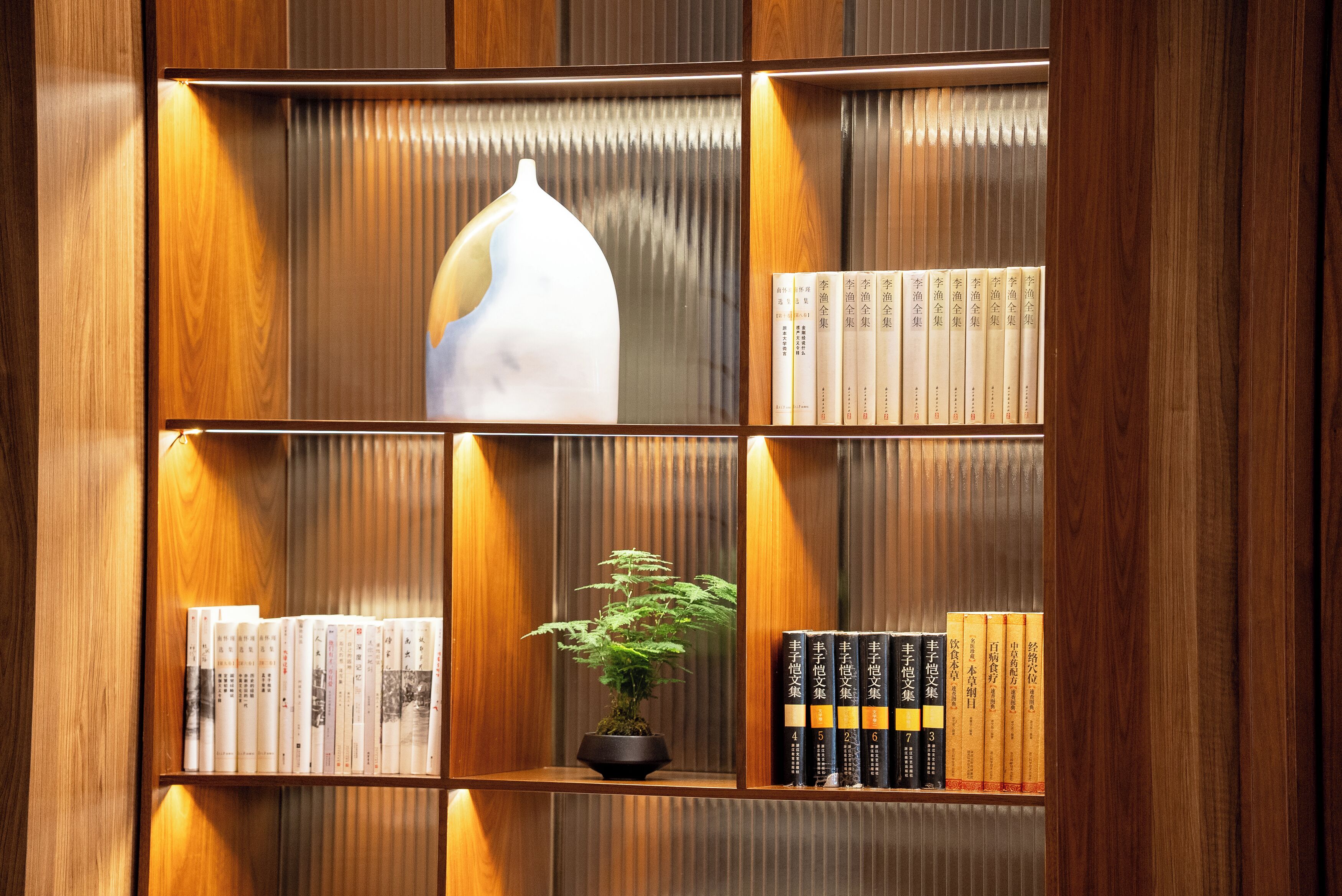 Ein Bücherregal mit Büchern und einer Vase.