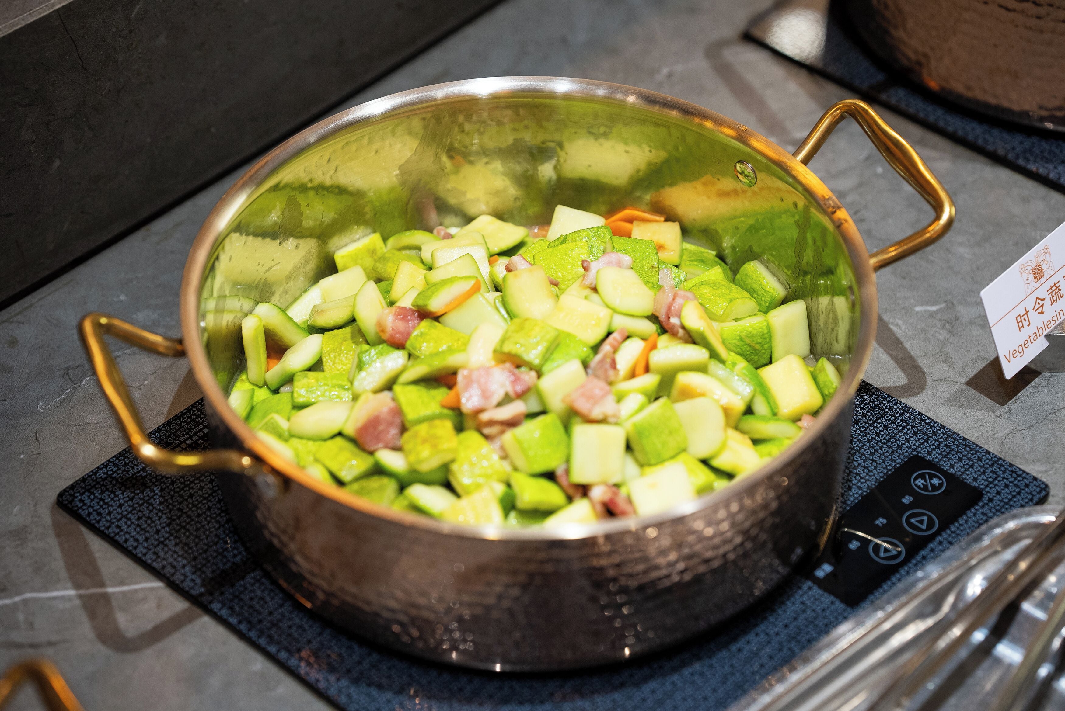 A stainless steel pot with a handle on a kitchen counter.