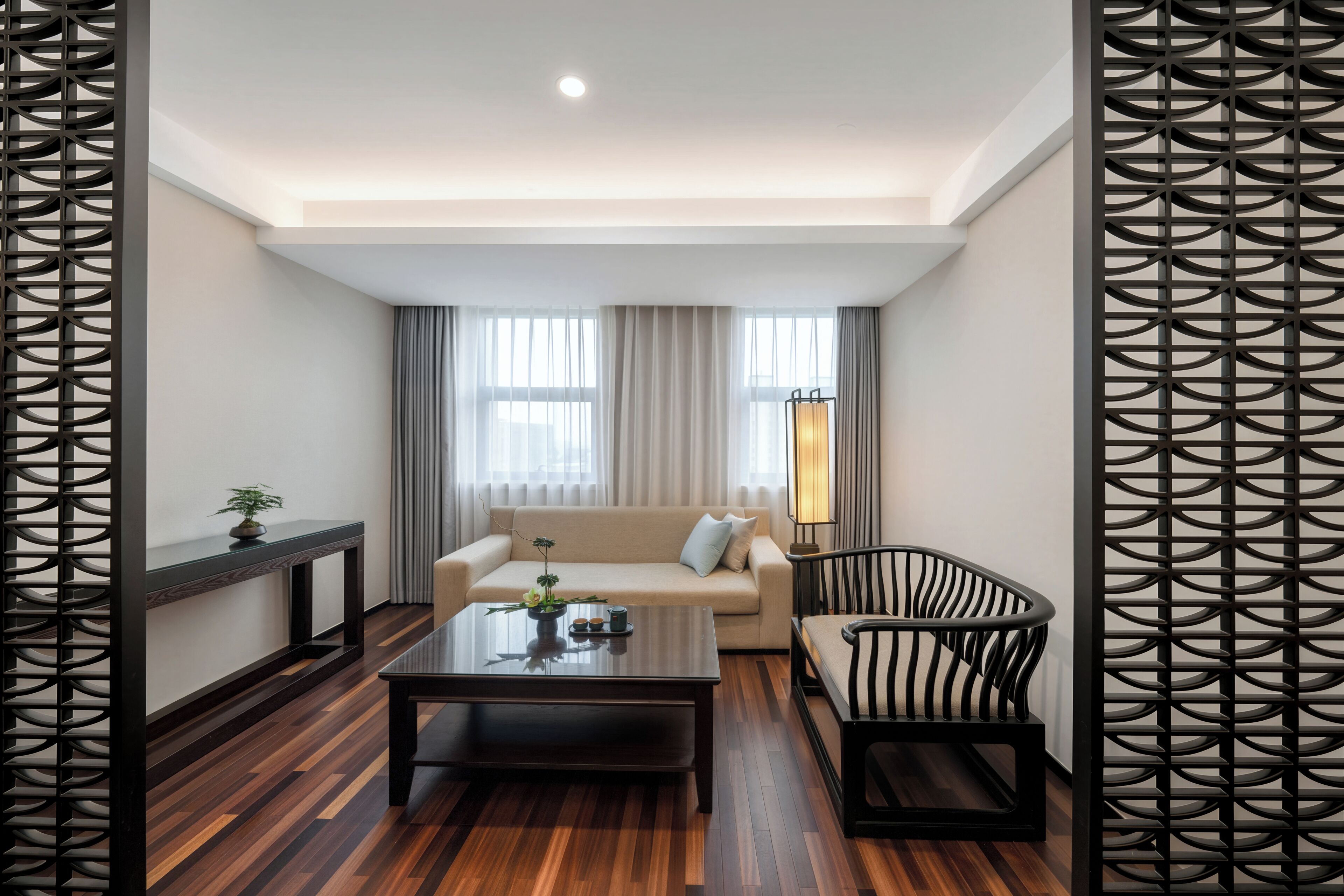 Uma sala de estar moderna com sofá, mesa de centro, poltrona e um painel decorativo.