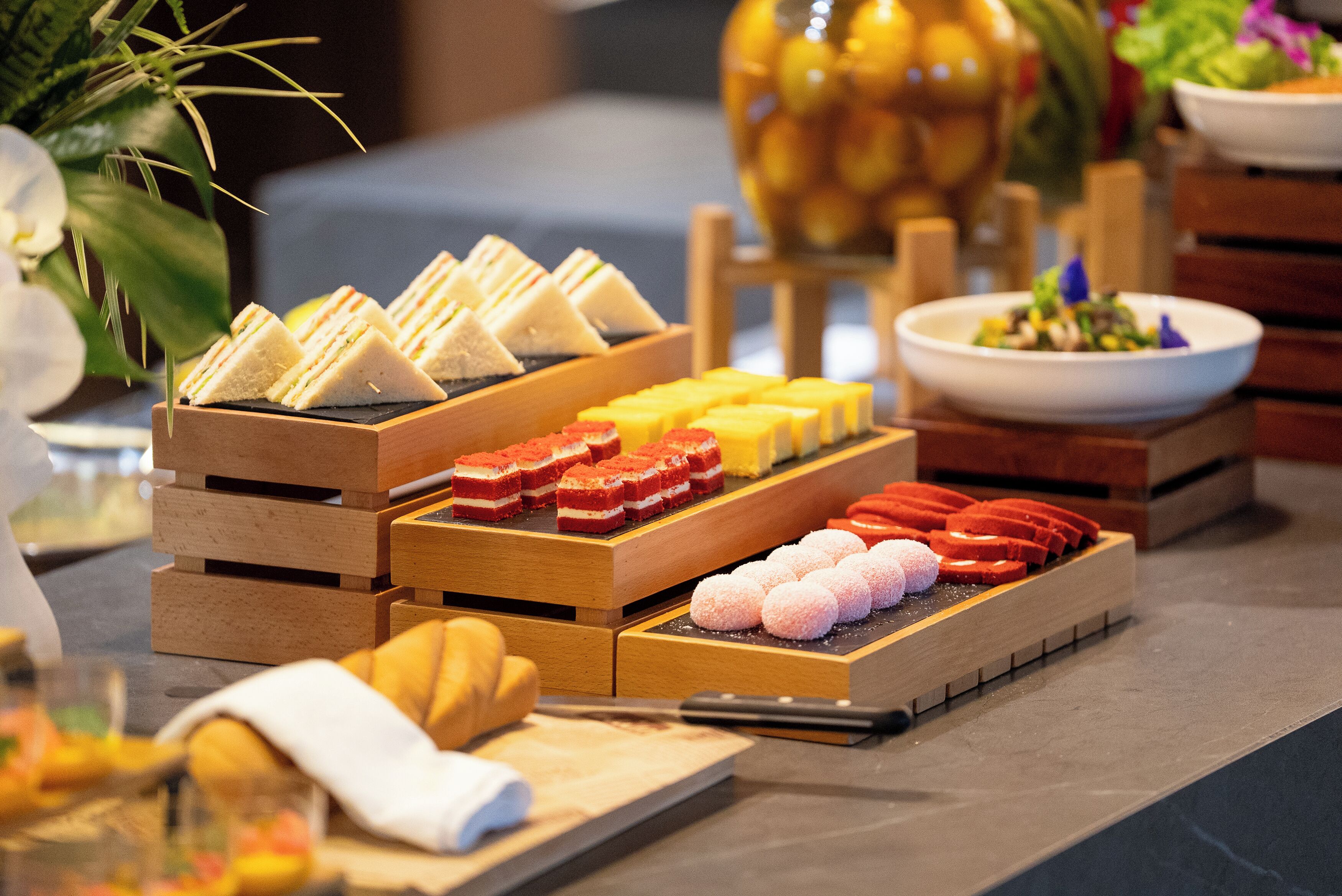 A buffet with various food items arranged in wooden trays.