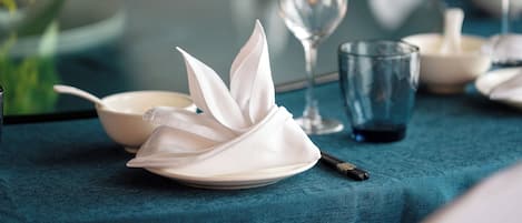 A table set with a white napkin, a glass, and a bowl.